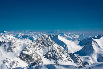 Scenic view of snowcapped mountains against blue sky