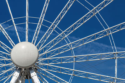 Low angle view of ferris wheel against blue sky