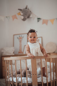 Portrait of cute boy sitting on chair at home