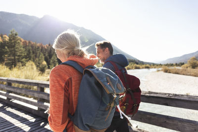 Austria, alps, couple on a hiking trip crossing a bridge