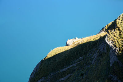 Low angle view of rock formation against clear blue sky