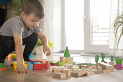 Side view of boy playing with toy at home