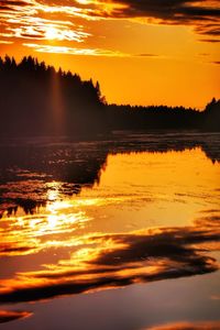 Scenic view of lake against orange sky