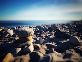 Stack of pebbles on beach against sky