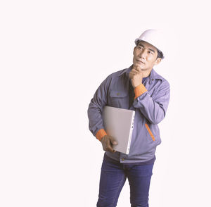 Young man wearing hat standing against white background