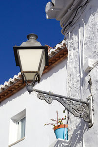 Low angle view of street light against building