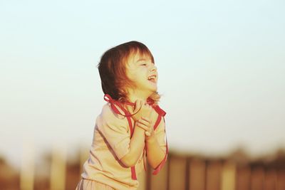 Cute boy looking away against sky