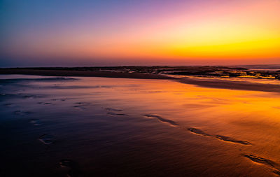 Scenic view of sea against orange sky