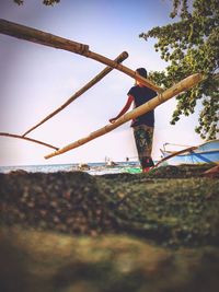 Low angle view of person climbing on street against sky