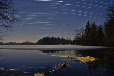 Scenic view of lake against sky at night