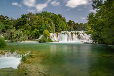 Scenic view of waterfall against sky