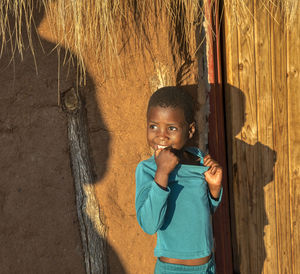 Portrait of boy standing against wall
