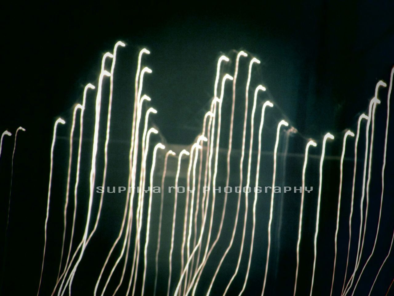 night, illuminated, low angle view, pattern, dark, abstract, in a row, no people, built structure, outdoors, design, repetition, sky, light - natural phenomenon, long exposure, architecture, close-up, black background, copy space, art and craft