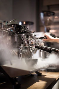 Coffee cup below machinery at cafe