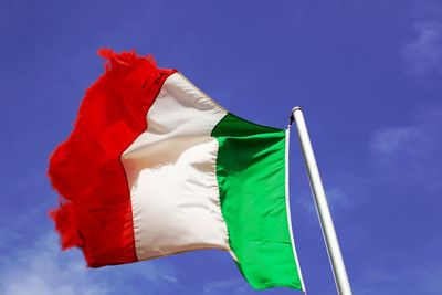 Low angle view of italian flag against blue sky