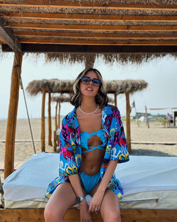 Portrait of smiling young woman standing at beach