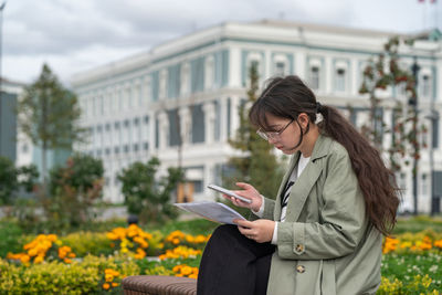 Young woman using mobile phone in city