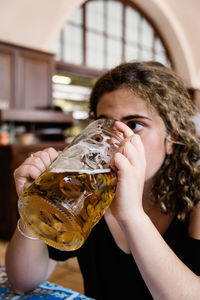 Close-up of young woman drinking beer at restaurant