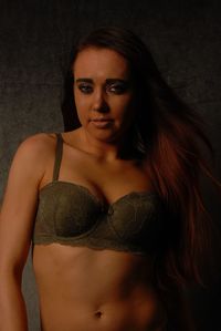Portrait of sensuous young woman standing in darkroom