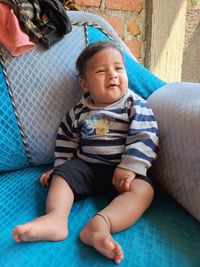 Portrait of boy sitting on sofa at home