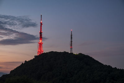 Low angle view of communications tower against sky at dusk
