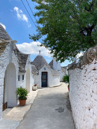 Footpath amidst buildings against sky