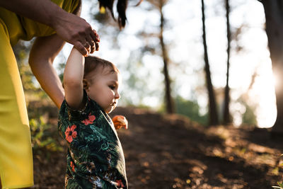 Midsection of child holding hands on land