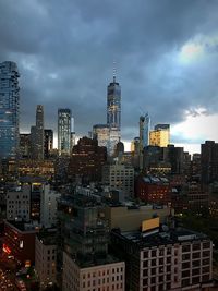 City lit up against cloudy sky