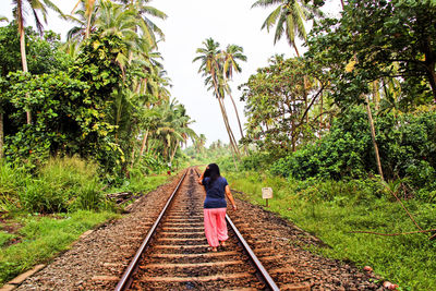 Rear view of man standing on railroad track