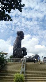 Low angle view of statue on staircase against sky