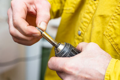 Close-up of man holding screwdriver