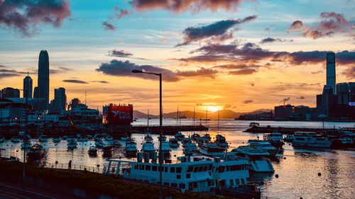 Boats moored at harbor during sunset