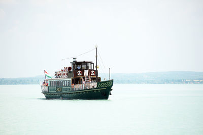 Boat sailing in sea against clear sky