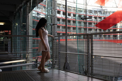 Side view of woman standing by railing