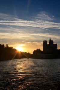 Sunset over river with buildings in background