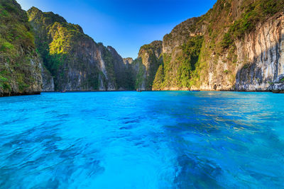 Scenic view of swimming pool by sea against blue sky