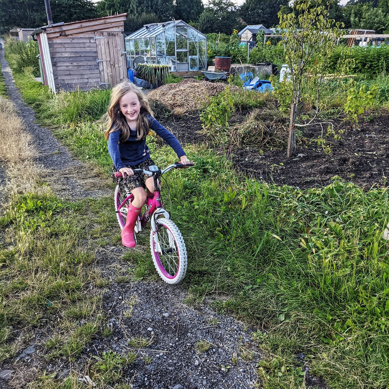 PORTRAIT OF GIRL RIDING BICYCLE ON GRASS