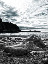 Close-up of pebbles on beach against sky