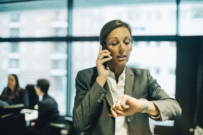 Young woman using mobile phone in office