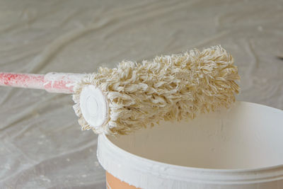 Close-up of paint roller on bucket