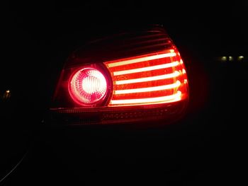 Close-up of illuminated lighting equipment against black background