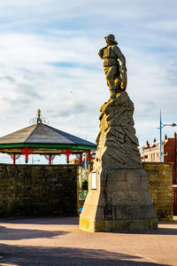 Statue of fisherman against sky