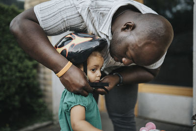 Father putting bike helmet on daughter