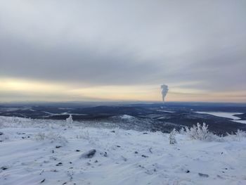 Scenic view of snow covered field against sky