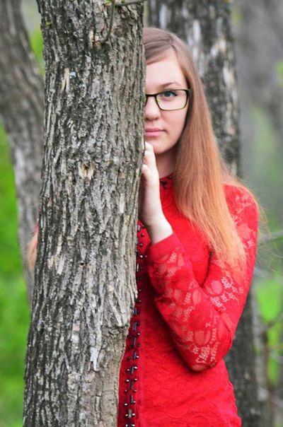 focus on foreground, tree trunk, tree, young women, lifestyles, young adult, front view, long hair, red, leisure activity, person, close-up, forest, casual clothing, outdoors, day, nature
