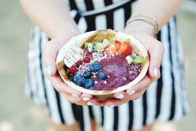 Midsection of woman holding food in container