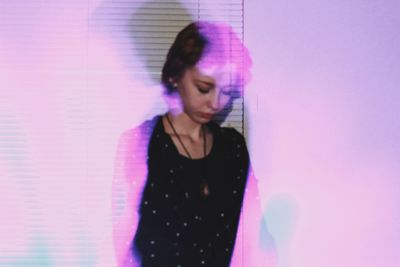 Digital composite image of woman standing against pink wall