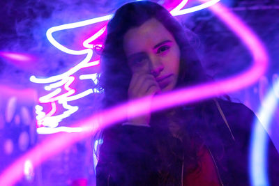 Portrait of young woman against light painting