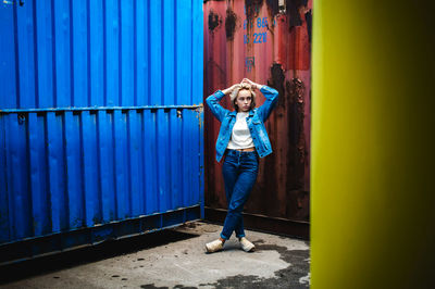 Woman standing against cargo container