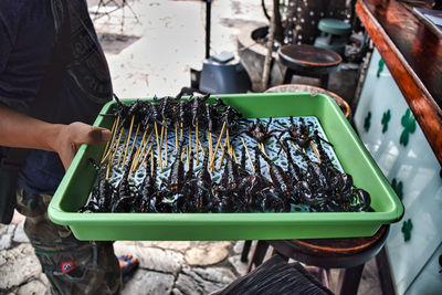 A local thai man is selling fried scorpions on the famous khaosan road or khao san road of bangkok